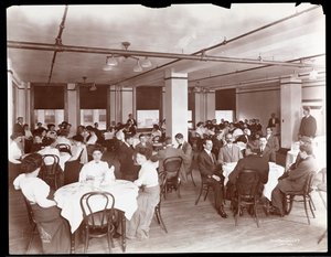 Vista di uomini e donne che cenano in una mensa a Parke, Davis e Co., chimici, Hudson e Vestry Streets, New York, 1910